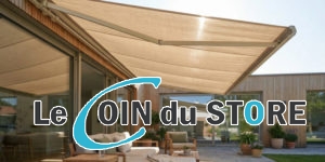 Store banne beige déployé au-dessus d'une terrasse en bois avec salon de jardin confortable.